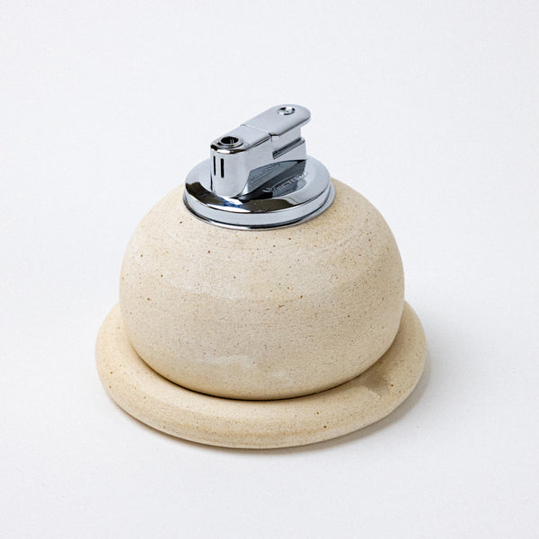 stone white ashtray with table lighter. handmade ceramic pebble table lighter in satin black. maison ko x olivia snow ceramics