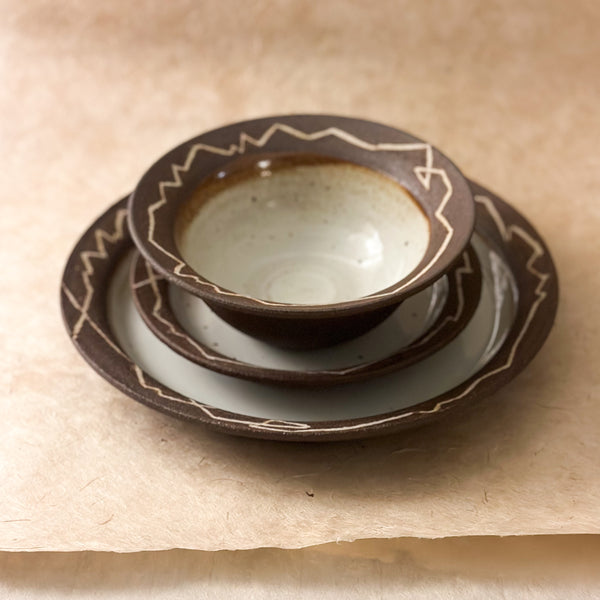 three piece handmade ceramic dinnerware set. bowl, small plate and large plate. dark brown and white dinnerware